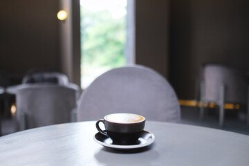 Closeup image of a cup of hot coffee on the table in cafe