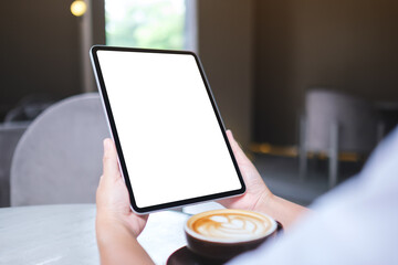 Mockup image of a woman holding digital tablet with blank white desktop screen in cafe