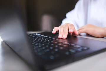 Closeup image of a woman working and touching on laptop computer touchpad