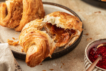 Delicious fresh croissants on ceramic plate and a cup of coffee, broken croissant with sweet feeling. Morning meal and breakfast concept