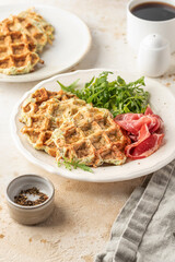 Zucchini waffles served with arugula salad and prosciutto. Healthy vegeterian food