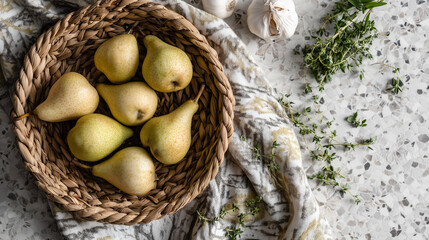 Basket of fresh ripe pears with herbs and garlic / lemons on light stone surface