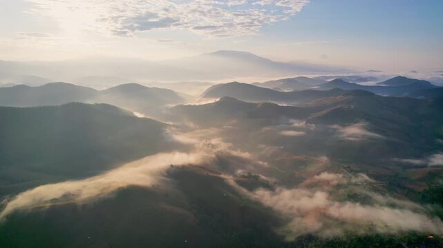 Aerial view of sunlight shines over barren deforest mountain with foggy among agricultural area in countryside at Chiang Mai, Thailand