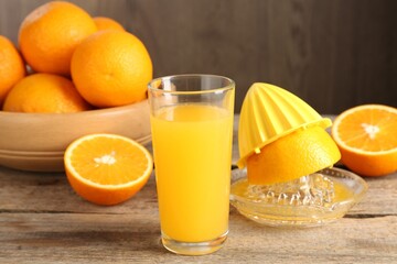 Tasty orange juice, fresh fruits and juicer on wooden table, closeup