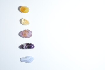 Aura. Different natural mineral stones on white background, flat lay. Space for text
