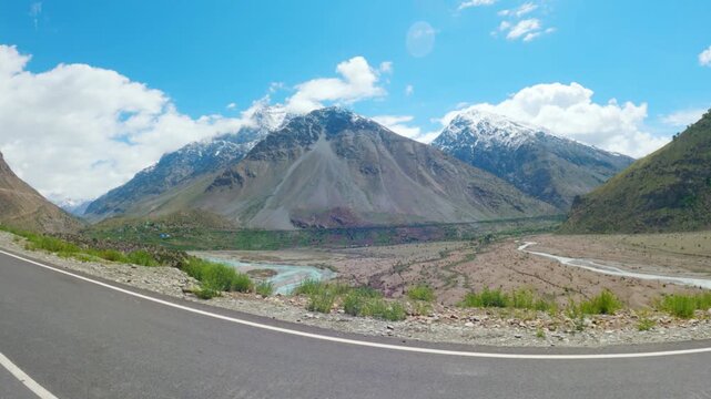4K shot of snowy Himalayan mountain range with clouds above them as seen on the way towards Darcha village from Jispa in Lahaul and Spiti district on Leh Manali highway in Himachal Pradesh, India.
