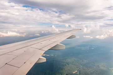 Obraz premium View from the airplane window at a beautiful cloudy sky and the airplane wing