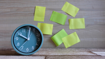 Alarm clock with sticky note on wood background. copy space, mockup,