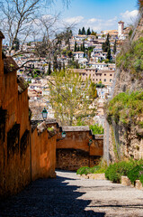 Spain, Europe: Sabika hill, city skyline and a cobbled alleyway leading to the Alhambra, palace and fortress complex in Granada, one of the most famous monuments of Islamic architecture
