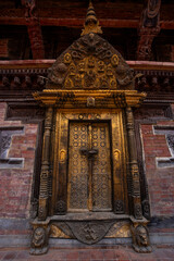 Close-up look of the gold ornamental door in Patan Durbar Palace in Kathmandu, Nepal. Traditional craftsmanship as old Nepali heritage.