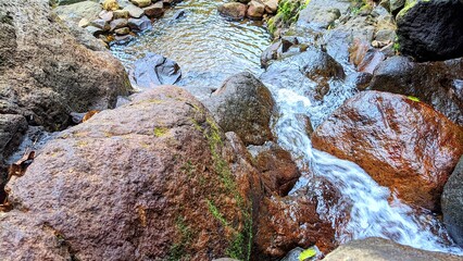 Clear river stream flowing over smooth rocks in a peaceful natural environment