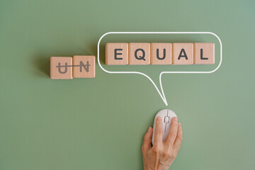 For equal rights or gender concept, EQUAL text on wooden cube blocks inside speech bubble with hand using wireless mouse