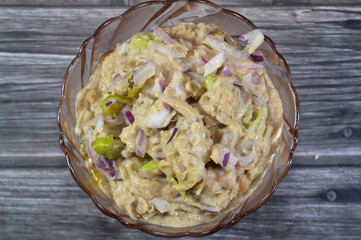 Mashed fava beans mixed with oil, sesame tahini, cumin, spices, slices of chili pepper and onion, traditional popular Egyptian fava bean done the Alexandrian way of Alexandria city of Egypt