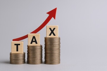 Rising Tax Burden: Conceptual Image of Increasing Taxes Represented by Stacked Coins and Upward Arrow