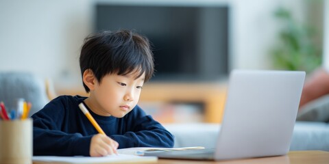 Concentrated Asian Boy Engaged in Online Learning, Completing Homework with Laptop and Pencil at Home