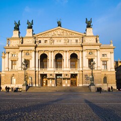 Fototapeta premium Stunning historic opera house facade with grand entrance and ornate architectural details under blue sky