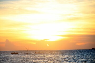 Obraz premium Golden sunset over calm ocean waters, ideal for nature, relaxation, and seascape themes