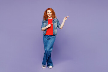 Full body young ginger woman she wearing red t-shirt denim shirt point index finger aside indicate on area mockup isolated on plain pastel light purple background studio portrait. Lifestyle concept.