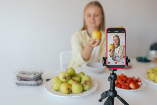 Middle-aged woman preparing homemade fruit leather, slicing fresh fruit in her kitchen for a healthy snack. Part of a series on organic treats and natural living. User-generated content