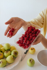 Caucasian woman preparing homemade fruit leather, slicing fresh fruit in her kitchen for a healthy snack. Part of a series on organic treats and natural living