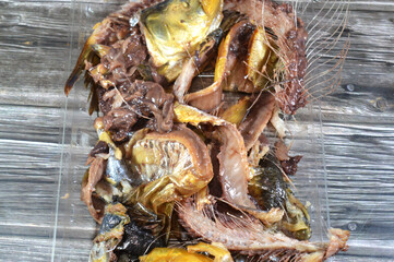 the waste, remains and remnants of Smoked salty Herring forage fish, salt-cured and smoked, also known as silver darlings, harvested for their flesh and eggs, and they are often used as baitfish