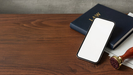 Legal concept with law book, official stamp and blank white screen for mockup on wooden desk with copy space, ideal for advertising, marketing, banner design and corporate legal services promotion
