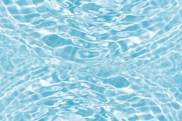 Blue water with ripples on the surface. Defocus blurred transparent blue colored clear calm water surface texture with splashes and bubbles. Water waves with shining pattern texture background.