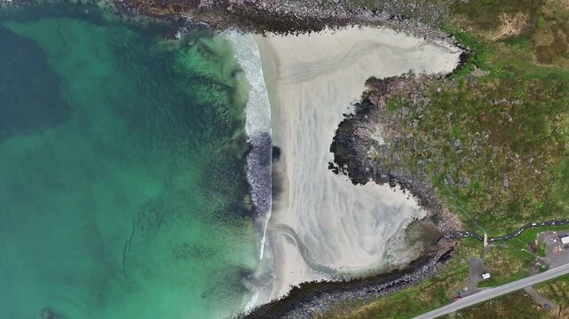 Roervikstranda beach in Lofoten with turquoise Arctic water and gentle waves, Birdseye aerial