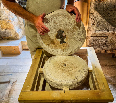 Miller showing the two halves of a traditional wheat grinding stones