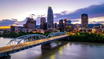 Obraz premium City skyline at sunset over river bridge