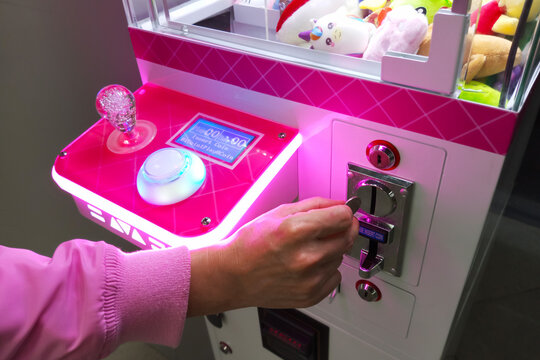 Children's slot machine glows in the dark. Throws a coin into the machine.