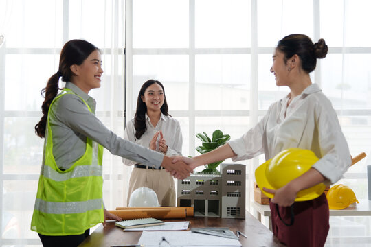 Architects shaking hands after successful meeting in the office