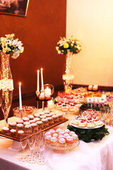 Catering table with sliced chocolate cakes decorated with fresh raspberries and nuts.