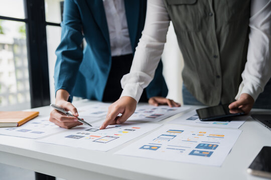 Developer team brainstorming user interface and experience designs for mobile application ux ui graphic prototype.