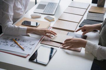 Interior designer presenting eco friendly wooden material samples for sustainable home decor
