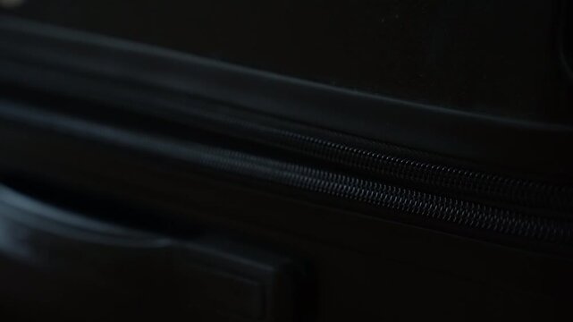 Stuck zipper of suitcase. A hand attempts to unlock a malfunctioning zipper, showing the frustration of dealing with stuck suitcase.