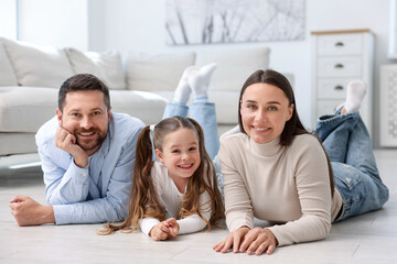 Fototapeta premium Parents and their daughter together on warm floor at home. Heating system