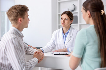 Obraz premium In vitro fertilization (IVF). Doctor encouraging couple during visit in reproductive clinic