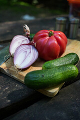 Tomatoes, Onions, and Cucumbers with Knife on Wooden Board in Forest