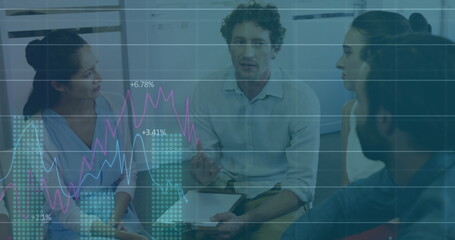 Consultants reviewing business data in modern meeting room, with tablet and line charts