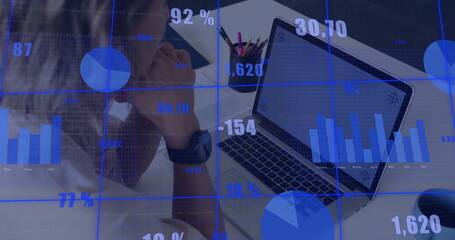 Businessman analyzing data on laptop in office, with pencil holder, smartphone, copy space