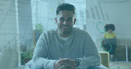 Smiling professional wearing sweater sitting on chair in home office, with financial charts overlay