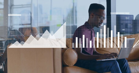 Working data analyst typing on laptop on office lounge sofa with digital graph overlays, copy space