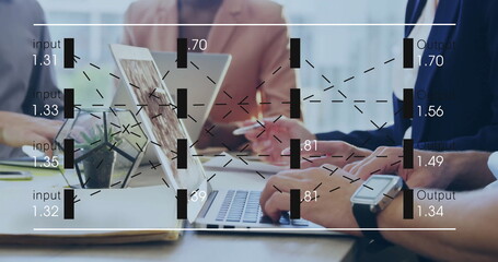 Collaborating team in blazers analyzing graphs in meeting room, with laptops and succulent pot