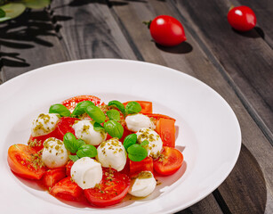 Fresh mozzarella and tomato salad with basil on wooden table