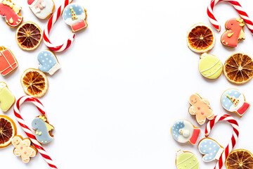Festive composition of Christmas and New Year gingerbread cookies and Christmas Candy Canes on white background, top view. Greeting concept