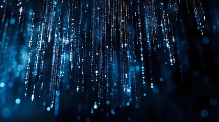 Glowing blue light streams falling against dark background create magical atmosphere with bokeh effect and sparkles for technology or celebration designs.