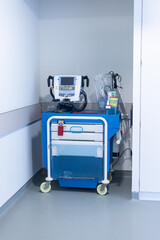 Medical crash cart with defibrillator in a hospital corridor, equipped for emergency resuscitation. © Pedro