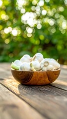 Sunlit wooden bowl of garlic bulbs sits on weathered wood outdoors