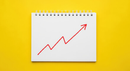 Obraz premium Upward Trend Line on Notebook Page Symbolizing Business Growth and Positive Financial Performance with Yellow Background for Optimistic Investment Outlook